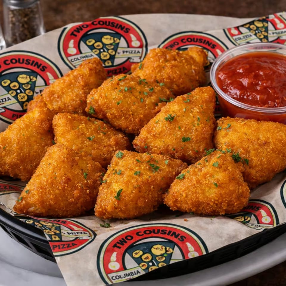 A basket of golden-brown fried ravioli from Two Cousins Pizza, garnished with parsley and served with marinara sauce.