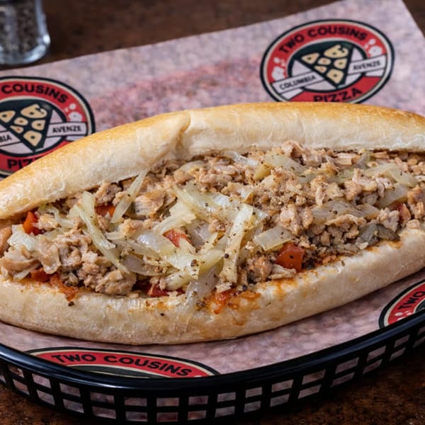 Two Cousins Pizza cheesesteak with chicken, onions, and peppers in a black basket.