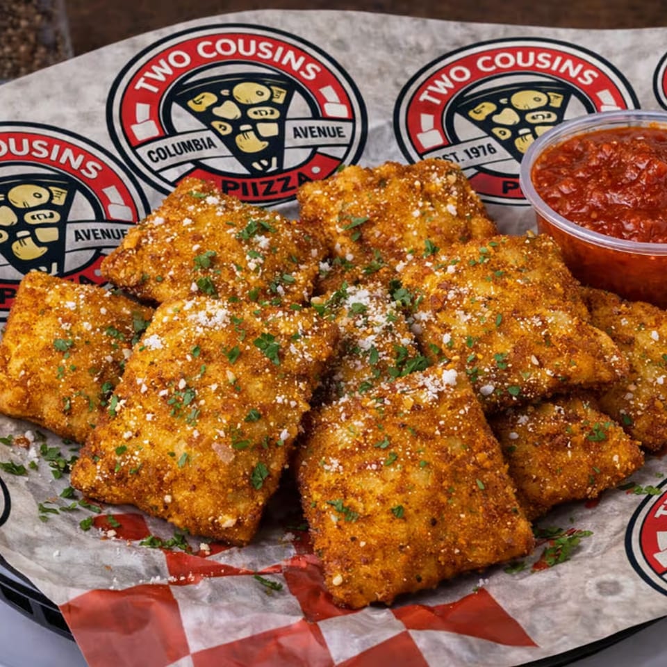 Golden-brown toasted ravioli with parmesan and parsley, served with a side of marinara sauce.