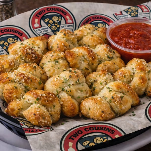 Two Cousins Pizza garlic knots with parmesan and parsley, served with marinara sauce.